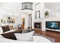 Bright living room with hardwood floors, cozy fireplace, and open floor plan at 10565 Wildhurst Cir, Highlands Ranch, CO 80126