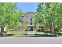Charming multi-story brick apartment building featuring manicured landscaping and mature trees at 2100 N Franklin St # 8, Denver, CO 80205