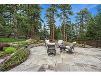 Outdoor patio with comfortable seating, mature trees and beautiful landscape, great for relaxing or entertaining at 1456 Shavano Ct, Evergreen, CO 80439