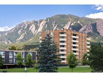 Scenic view of a brick apartment building nestled beneath a majestic mountain range, offering a serene living environment at 850 20Th St # 203, Boulder, CO 80302