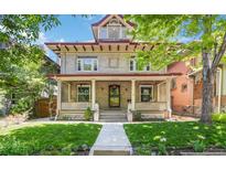 Charming two-story home with a welcoming front porch and well-manicured lawn at 1226 Clayton St, Denver, CO 80206