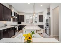 Modern kitchen with stainless steel appliances, center island, and dark cabinetry at 522 Meridian Ln, Superior, CO 80027