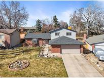 Charming brick and siding home with a two-car garage and well-maintained front yard under a bright blue sky at 7515 W Polk Ave, Littleton, CO 80123