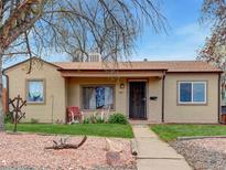Charming home with a well-maintained front yard, inviting walkway, and cozy porch chairs at 675 S Quivas St, Denver, CO 80223