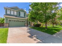 Charming two-story home with a well-manicured lawn and attached two-car garage at 19466 E 59Th Dr, Aurora, CO 80019