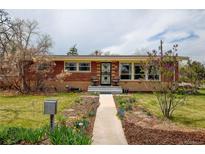 Charming brick home with a manicured front yard and inviting walkway at 345 Central Ave, Brighton, CO 80601