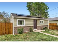 Charming single-story home with solar panels, stone accents, and well-maintained front yard at 7101 E 66Th Ave, Commerce City, CO 80022