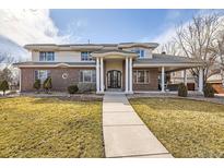 Stately brick and stucco home with a covered entrance and well-maintained landscaping at 6790 W Crestline Ave, Littleton, CO 80123