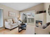 Cozy living room featuring a fireplace, sliding door to a deck, and modern furnishings at 8406 Pebble Creek Way # 202, Highlands Ranch, CO 80126