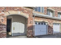 A townhome with a red brick exterior, entry doorway and attached one car garage at 8944 Fox Dr # 6-103, Denver, CO 80260