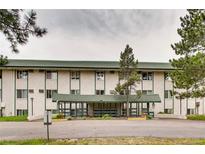 Exterior shot of apartment building with green trim, white exterior, and covered entry at 8826 E Florida Ave # 103, Denver, CO 80247