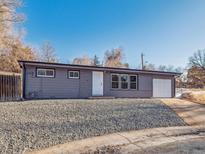 Ranch style home with gray exterior, landscaped yard, and attached garage at 4348 S Jason St, Englewood, CO 80110