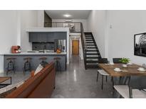 Open-concept living space with a kitchen bar, dining area, and living room at 1601 Park Ave # 112, Denver, CO 80218