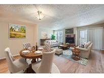 Spacious living room and dining area featuring a fireplace, hardwood floors, and lots of natural light at 701 Harlan St # E27, Lakewood, CO 80214