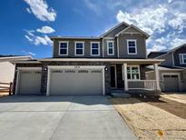 Charming two-story home featuring a three-car garage, stone accents, and a welcoming front porch at 24770 E 39Th Ave, Aurora, CO 80019