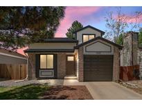 Charming two-story home featuring a brick facade, well-manicured lawn, and attached garage at 7633 Gray Way, Arvada, CO 80003