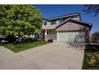 Charming two-story home featuring a brick-accented garage and well-manicured front lawn at 22739 E Prentice Pl, Aurora, CO 80015