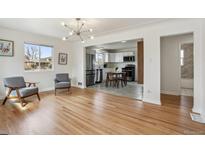 Bright living room featuring hardwood floors, modern lighting, and an open layout to the kitchen at 3662 Jasmine St, Denver, CO 80207