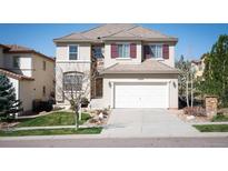 Charming two-story home featuring a stucco exterior, tile roof, and a two-car garage at 2559 S Kendrick St, Lakewood, CO 80228