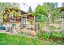 Charming home with brick and wood facade, landscaped front yard, and inviting front entrance at 10342 Monterey Cir, Northglenn, CO 80260