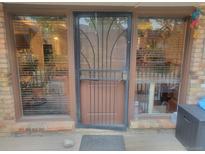 Inviting front entrance featuring a secure metal screen door and large windows bringing natural light at 2190 S Holly St # 213, Denver, CO 80222