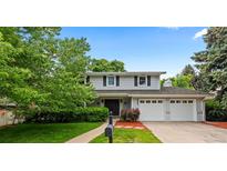 Charming two-story home with a two-car garage, well-maintained lawn, and beautiful landscaping at 3966 S Magnolia Way, Denver, CO 80237