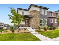 Charming home featuring a stone facade, cozy porch, and well-maintained landscaping at 6211 Stable View St, Castle Pines, CO 80108