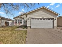 Charming single-story home featuring a two-car garage, a well-maintained lawn and a cozy front porch at 5688 Alcott St, Denver, CO 80221