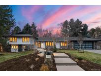 Stunning home exterior featuring landscaped front yard, modern design elements, and a welcoming entryway with a colorful dusk sky at 4071 S Dahlia St, Cherry Hills Village, CO 80113