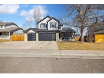 Charming two-story home featuring a three-car garage and a covered front porch at 8983 W Capri Ave, Littleton, CO 80123