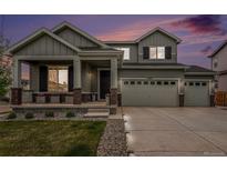 Two-story home boasts a three-car garage, a covered porch, and well-maintained landscaping at 12405 E 101St Dr, Commerce City, CO 80022