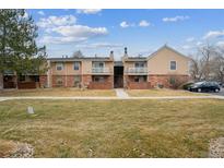 Exterior of a two-story townhome featuring a well-maintained lawn and balcony at 3320 S Ammons St # 104, Lakewood, CO 80227