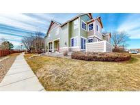 Charming two-story townhome featuring a well-maintained lawn and inviting walkway to the front door at 15800 E 121St Ave # L1, Brighton, CO 80603