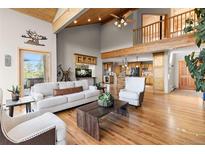 Bright, open living room with vaulted ceilings, hardwood floors, and access to a balcony at 30717 Conifer Mountain Dr, Conifer, CO 80433
