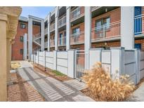 Apartment complex featuring brick facade, open walkways, and well-maintained landscaping at 1 N Pearl St # 102, Denver, CO 80203