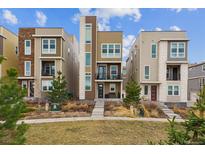 Modern townhome exterior featuring multiple levels, balconies, and manicured landscaping at 3698 Penang Dr, Castle Rock, CO 80109
