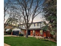 Charming two-story home featuring a brick facade, attached garage and a lush green lawn at 8736 E Easter Ave, Centennial, CO 80112