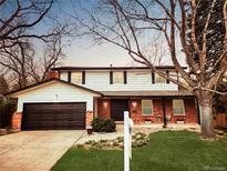 Charming two-story home with a brick facade, attached garage, and well-manicured lawn and mature shade trees at 8736 E Easter Ave, Centennial, CO 80112