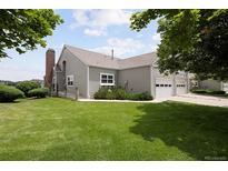 Lovely home exterior featuring a manicured lawn and an attached two car garage at 15555 E 40Th Ave # 36, Denver, CO 80239