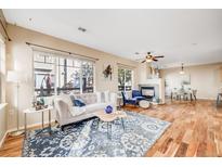 Bright living room with hardwood floors, fireplace, ceiling fan, and ample natural light at 13025 Grant E Cir # A, Thornton, CO 80241