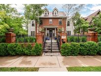 Stately brick home featuring manicured landscaping, black iron fence, and an inviting entrance at 1332 S Lafayette St, Denver, CO 80210