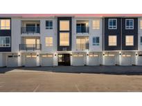 Modern townhome complex featuring individual garages and private balconies at 6153 N Ceylon St # 307, Denver, CO 80249