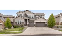 Beautiful two-story home with a three car garage and stone and siding facade at 16227 Pikes Peak Dr, Broomfield, CO 80023