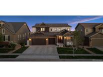 Charming two-story home with a two-car garage, manicured lawn, and inviting front porch at 3056 Yale Dr, Broomfield, CO 80023