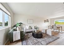 Bright living room featuring modern furnishings, a patterned rug, and light wood flooring at 9740 W 104Th Dr, Westminster, CO 80021