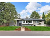 Charming single-story home with lush front lawn, mature trees, and gray exterior at 6088 S Lakeview St, Littleton, CO 80120