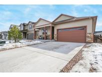 Two-story house with brown garage door and stone accents at 2147 Prairie Smoke Dr, Monument, CO 80132