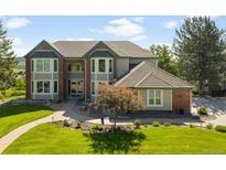 Charming two-story home featuring a beautifully landscaped front yard, inviting walkway, and an arched entryway at 50 Deerwood Dr, Littleton, CO 80127
