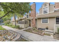 Charming townhome exterior with brick chimney, lovely landscaping, and inviting walkway at 14193 E Radcliff Cir, Aurora, CO 80015