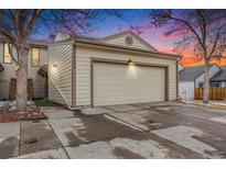 Beige exterior of townhouse with two-car garage and landscaping at 14204 E Baltic Cir, Aurora, CO 80014